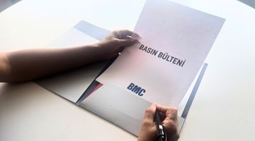 Bir kadın bir adama BMC kataloğundan bir şey gösteriyor.
